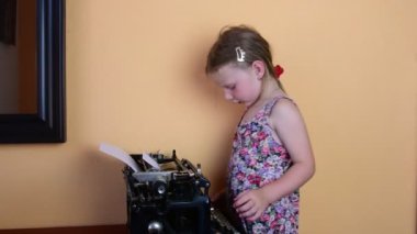 Tatlı küçük kız vintage daktiloda yazar. Okul öncesi kavram çocukluk konsept. Okul öncesi gibi sevimli kız