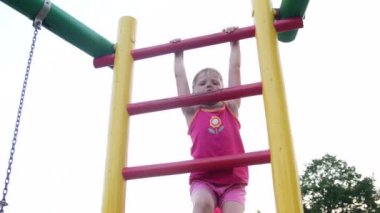 Sevimli küçük kız görünümünü Bahçesi adlı bir merdiveninde tırmanıyor