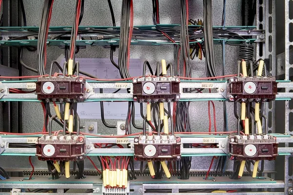 Old contactors and safety relays for emergency stop monitoring in control cubicle. Closeup