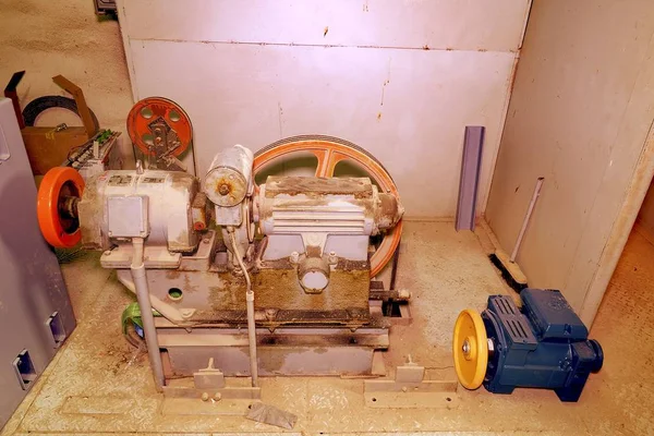 Partie de l'ascenseur industriel. Roue de poulie et moteur dans la salle des machines. Reconstruction de l'ascenseur industriel — Photo