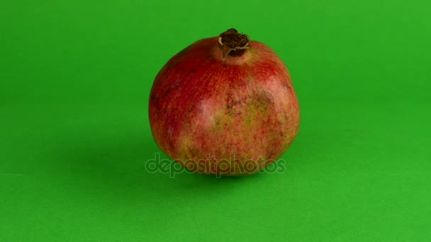 Granata mela ruota su sfondo verde. Sfondo chiave del cromo. Melograno o sfondo verde — Video Stock