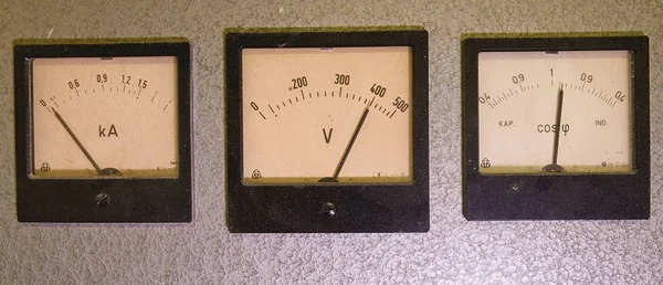 Три старых аналоговых прибора - счетчик мощности, вольтметр и амперметр, изолированные на сером фоне — стоковое фото