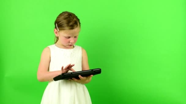 Flicka använder tangentbordet. Small flicka på chroma key bakgrund. — Stockvideo