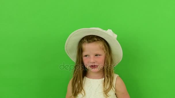 Симпатичная маленькая девочка на фоне хроматического ключа. Маленькая девочка, одетая в романтическое платье. Белая шляпа и свадебное платье. Фон хромы . — стоковое видео