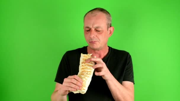 Oudere midden oude mens. Portret van een volwassen man eet de fastfood - kebab afkorting gyros voor groen scherm. — Stockvideo