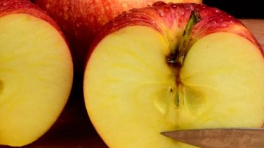 Organik Kırmızı elma sulu meyve, sağlıklı beslenme serinletici su damlaları içinde kaplı. Siyah arka plan. Elma ikiye. Bıçak ve doğrama kurulu.