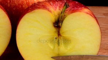 Organik Kırmızı elma sulu meyve, sağlıklı beslenme serinletici su damlaları içinde kaplı. Siyah arka plan. Elma ikiye. Bıçak ve doğrama kurulu.