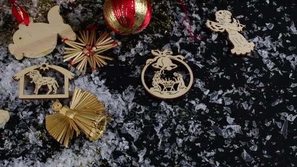 Christmas decoration. Christmas balls, golden flakes and snowflakes on black background. Wooden Christmas decoration. — Stock Video