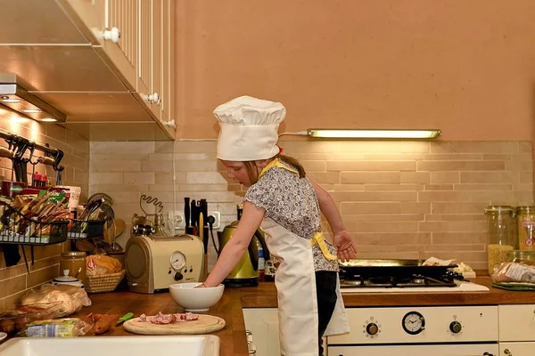 Petite fille mignonne cuisine dans la cuisine rurale. Petite fille prépare une pizza . — Photo