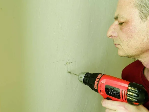 Hombre adulto perforando un agujero en la pared. Concepto de primer plano . —  Fotos de Stock