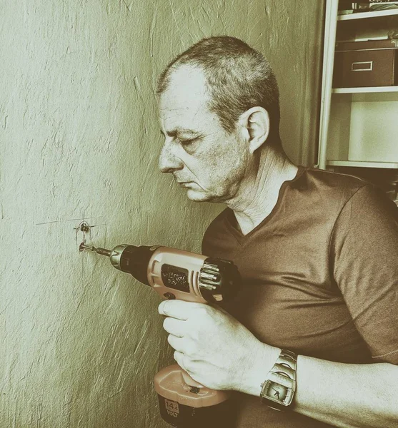 Hombre adulto perforando un agujero en la pared. Concepto de primer plano . —  Fotos de Stock