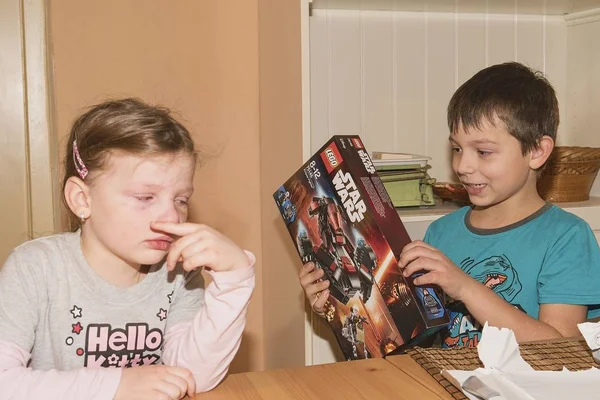 Rapaz a celebrar o nono aniversário. O presente de aniversário é LEGO Star Wars. Irmão e sua irmã decepcionada . — Fotografia de Stock