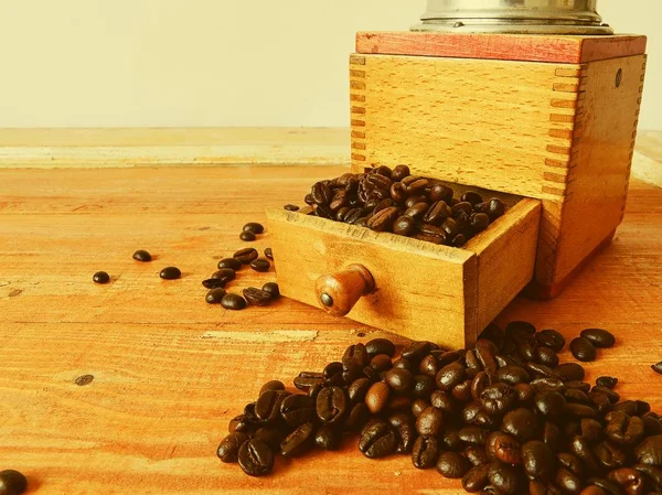 Molino de café vintage y granos de café sobre fondo de madera — Foto de Stock