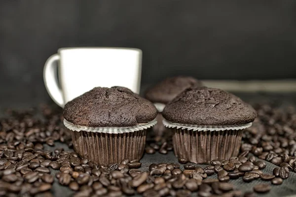 Темный кекс, чашки кофе и кофейных зерен на черном фоне. Добавить темные контрасты — стоковое фото