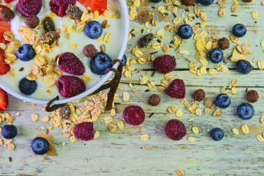 Yapılan yoğurt, böğürtlen, ahududu, yaban mersini, müsli ile tipik bir gerçek kahvaltı bileşimi. Kavramı: fitness, beslenme, sağlık ve kahvaltı. Düz tasarım. Üstten Görünüm