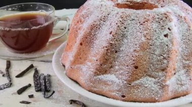 Eski ahşap arka plan üzerinde siyah çay ve adet vanilya kupa ile kum pasta moda. Rustik beyaz zemin üzerine yumurta sarısı sünger kek