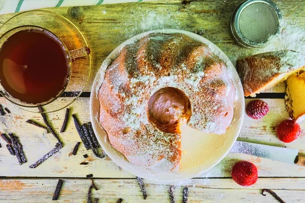 Kue pasir kuno dengan secangkir teh hitam dan potongan vanila dengan latar belakang kayu. Egg-yolk sponge cake dengan stawberry pada latar belakang putih berkarat — Stok Foto