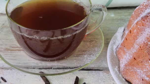Régi vágású homok sütemény csésze fekete tea és a vanília darab fa háttér. Tojássárgája piskóta stawberries rusztikus fehér háttér — Stock videók