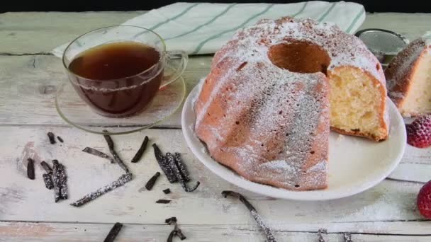 Bolo de areia à moda antiga com xícara de chá preto e pedaços de baunilha em fundo de madeira. Bolo de esponja de gema de ovo com amoras no fundo branco rústico — Vídeo de Stock