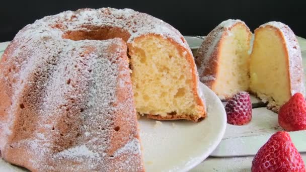 Torta de arena a la antigua con taza de té negro y trozos de vainilla sobre fondo de madera. Pastel de esponja de yema de huevo con fresas sobre fondo blanco rústico — Vídeo de stock