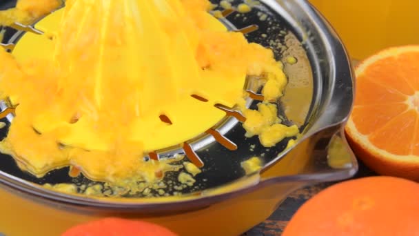 Mandarini, arance, un bicchiere di succo d'arancia e strizzacervelli manuali di agrumi su fondo blu di legno. Arance tagliate a metà — Video Stock