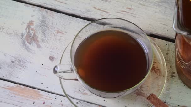 Tè nero, spremiagrumi manuali con limoni. Una brocca di tè nero e cubetti di zucchero . — Video Stock