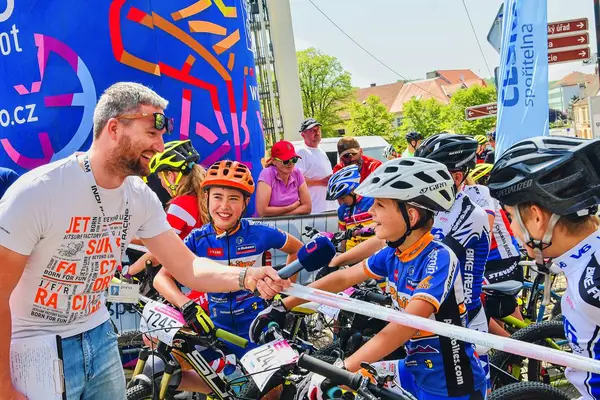 Compétition traditionnelle de vélo Vélo pour la vie. Les coureurs attendent le départ. Journaliste de la télévision tchèque demandant jeune cycliste . — Photo