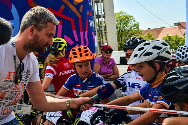 Compétition traditionnelle de vélo Vélo pour la vie. Les coureurs attendent le départ. Journaliste de la télévision tchèque demandant jeune cycliste . — Photo