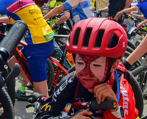 Compétition traditionnelle de vélo Vélo pour la vie. Les coureurs attendent le départ. Jeune cycliste a maquillage comme Spiderman  . — Photo
