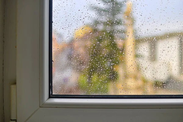Water stains on the glass behind the rain. Wet home window with raindrops after summer rain. — Stock Photo, Image
