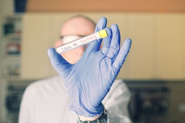 Doktor elinde COVID 19 Coronavirus aşısı tutuyor, örnek tüpte enfeksiyon örneği, aşı ve şırınga COVID-19 'dan korunma, aşılama ve tedavi için kullanılıyor..