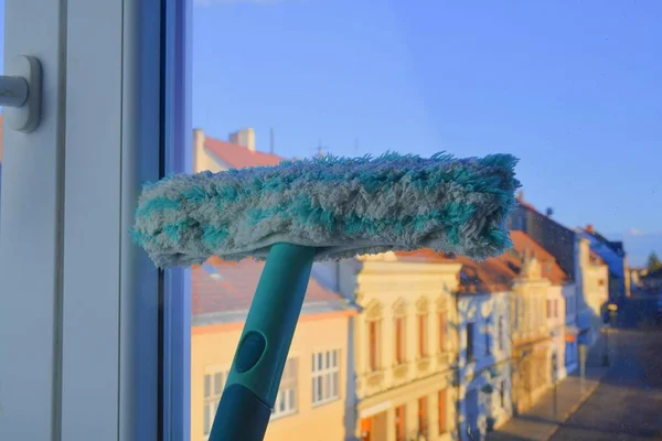 Cleaning windows with a squeegee. Cleaning concept. Washing window, close up.