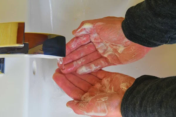 Um plano de perto. Um homem a lavar as mãos na casa de banho. Conceito de estilo de vida . — Fotografia de Stock
