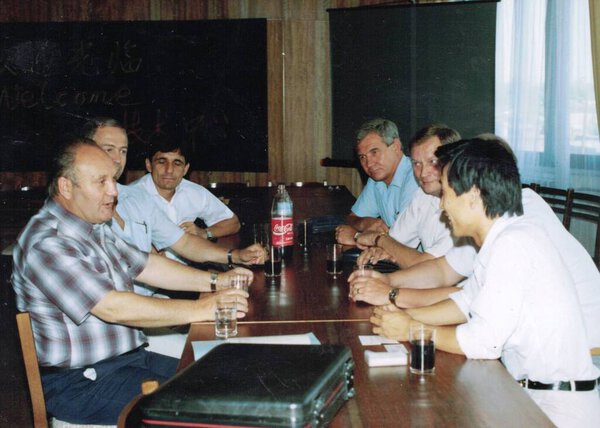 Ретро-фото показывает, как китайский бизнесмен беседует со своими европейскими партнерами на деловой встрече
