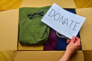 Bağış konseptleri, ellerinde DONATE metni tutan bir adamın elleri. Diğer insanlarla bir şeyler vermek ve paylaşmak..