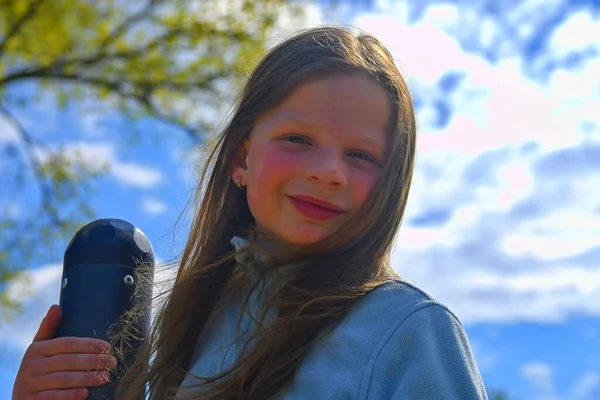 Retrato linda niña en el patio de recreo en el día cálido y soleado al aire libre. Ocio activo de verano para niños . —  Fotos de Stock