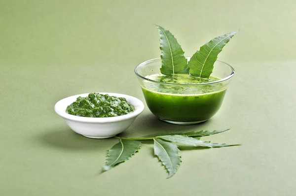 Folhas de Neem medicinal pasta e suco com folhas no fundo verde — Fotografia de Stock