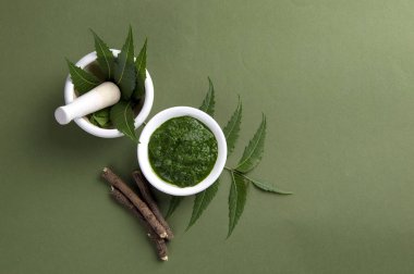Harç ve havaneli ile tıbbi Neem yaprağı yapıştırın ve üzerinde yeşil renkli çırpı