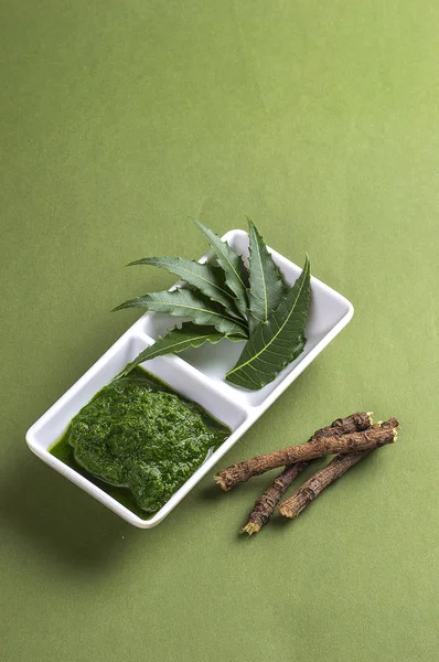 Tıbbi Neem Yapıştır yapraklar ve dallar ile yeşil arka plan üzerinde bırakır