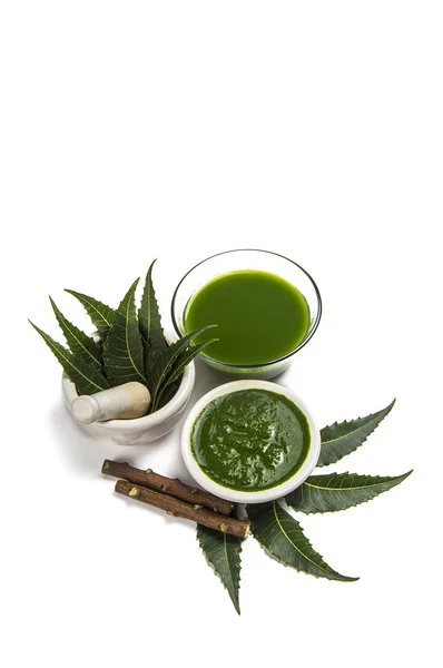 Medicinal Neem leaves in mortar and pestle with neem paste, juice and twigs — Stock Photo, Image