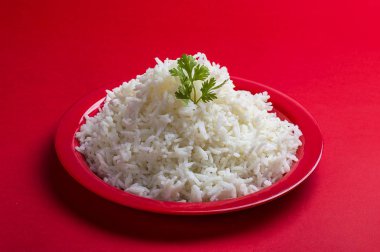 Düz beyaz basmati pirinç kırmızı zemin üzerine kırmızı bir tabak içinde pişmiş