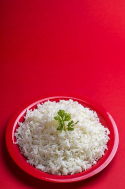Düz beyaz basmati pirinç kırmızı zemin üzerine kırmızı bir tabak içinde pişmiş