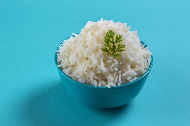 Düz beyaz basmati pilav corriander mavi zemin üzerine mavi bir kase ile pişmiş