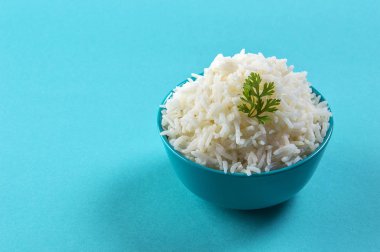 Düz beyaz basmati pilav corriander mavi zemin üzerine mavi bir kase ile pişmiş