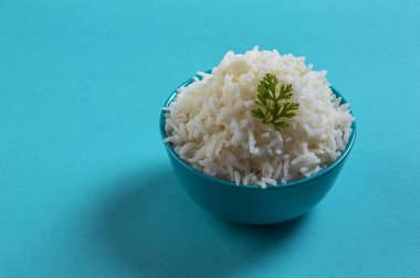 Düz beyaz basmati pilav corriander mavi zemin üzerine mavi bir kase ile pişmiş
