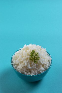 Düz beyaz basmati pilav corriander mavi zemin üzerine mavi bir kase ile pişmiş