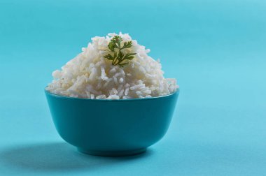 Düz beyaz basmati pilav corriander mavi zemin üzerine mavi bir kase ile pişmiş