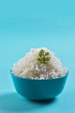 Düz beyaz basmati pilav corriander mavi zemin üzerine mavi bir kase ile pişmiş