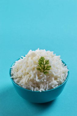 Düz beyaz basmati pilav corriander mavi zemin üzerine mavi bir kase ile pişmiş