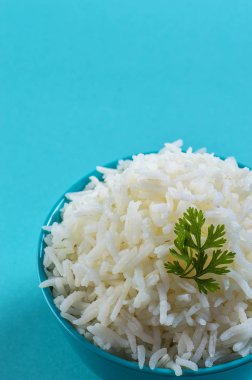 Düz beyaz basmati pilav corriander mavi zemin üzerine mavi bir kase ile pişmiş